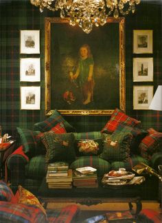 an instagram photo of a living room with green and red plaid couches, paintings on the wall