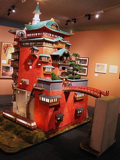 a model of a red building on display in a room with pictures and other items