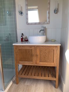 a bathroom with a sink, mirror and shower stall