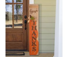 a wooden sign with the words give thanks on it and an orange ribbon tied to it