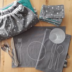 cloths and utensils are laid out on the floor to be used as placemats