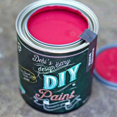 a can of pink paint sitting on top of a table next to a container with the words diy paint