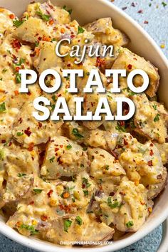 cajun potato salad in a white bowl with the words cajun potato salad above it