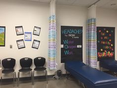 a room with chairs and bulletin boards on the wall next to each other in front of a blue bench