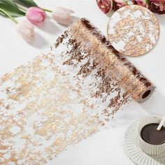 a white table topped with flowers next to a cup of coffee