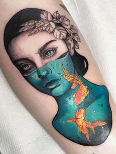 a woman's face with fish in the water and flowers on her head tattoo