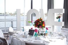 the table is set with flowers and candles for an anniversary celebration at the waterfront restaurant