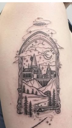 a hogwarts castle tattoo on the back of a woman's shoulder