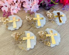 three small crosses are sitting next to some flowers