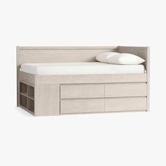 a bed with drawers underneath it and a pillow on the top of each drawer, in front of a white background