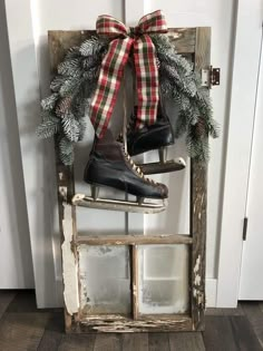 a pair of ice skates sitting on top of a wooden ladder with a christmas wreath