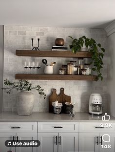 a kitchen with white cabinets and wooden shelves