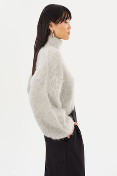 All about luxury and edge, the GARCELLE Wool Sweater is knitted from a plush alpaca blend that exudes sophistication. The loose fit and high-low hem add a modern, yet refined touch. Featuring a cropped length, bold turtleneck, and balloon sleeves, it's perfect with high-waisted jeans for an effortless, casual look or with the matching TARAN Wool Pants for the ultimate cold-weather statement. Wool Turtleneck, Wool Pants, Swim Accessories, Balloon Sleeves, High Low Hem, Wool Sweater, Wool Sweaters, Dress Accessories, Skirt Pants