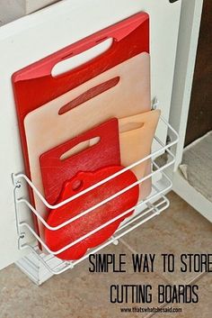 a white dish rack with red cutting boards in it