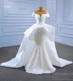 a white wedding dress on display in a room