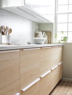 a kitchen with wooden cabinets and white counter tops