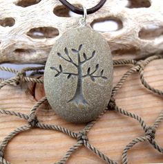 a stone with a tree on it is sitting on a piece of wood and rope