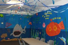 a room decorated in blue and orange with fish, sharks, and bubbles