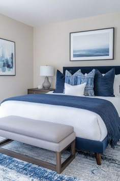 a bedroom with blue and white decor on the walls, carpeted flooring and a large bed