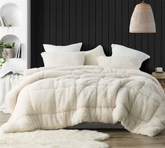 a bed with white fluffy blankets and pillows