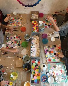 several people sitting at a table making art work