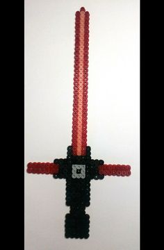 a cross made out of legos with red and black beads on it's sides