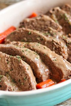 meatloaf with carrots, peppers and gravy in a blue dish