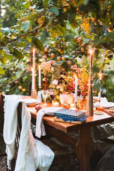 the table is set with candles, books and other things to eat in front of it