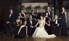 a large group of people in formal wear posing for a photo on a wooden floor