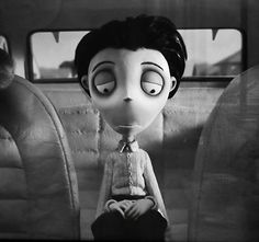 a black and white photo of a cartoon character sitting in the back of a car