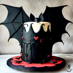 a black cake decorated with bats and hearts