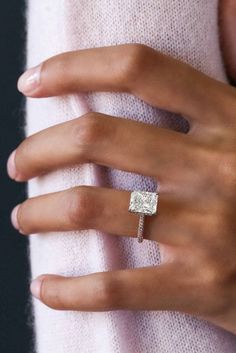 a woman's hand with a diamond ring on it