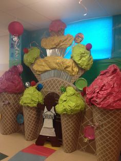 some ice cream cones are sitting in the middle of a room with decorations on it