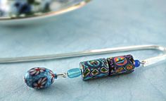 a close up of a pair of earrings on a table with a plate in the background