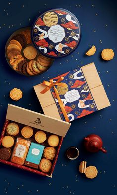 an assortment of cookies, crackers and teas on a blue background with gold confetti