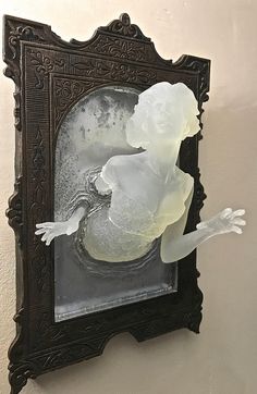 a mirror that has some kind of glass in it with a woman's face on it