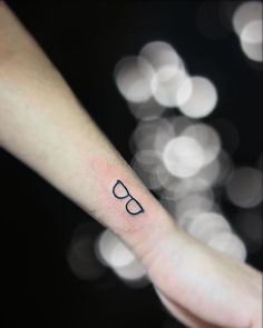 a person's hand with a small tattoo on it