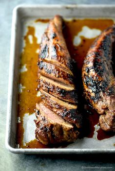 two pieces of meat sitting on top of a pan