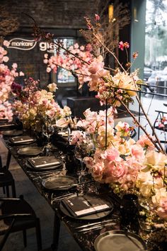 a long table with flowers and plates on it