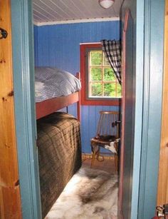 there is a bunk bed in the room with blue walls and wood trimmings