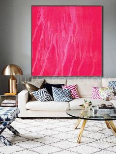 a living room filled with furniture and a large pink painting on the wall above it