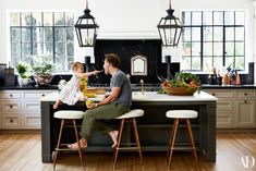 a man sitting at a kitchen counter with a baby