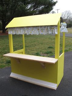 a yellow food cart sitting on the side of a road next to a grass covered field