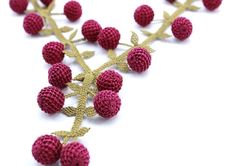 crocheted strawberries on a branch with leaves and stems in the shape of hearts