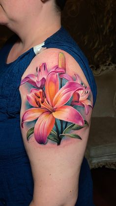 a woman with a tattoo on her arm has flowers painted on the back of her shoulder