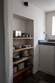 a kitchen with open shelving and dishes on the shelves