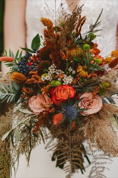 a bridal holding a bouquet of flowers and foliage in front of a woman's face