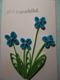 there is a card with flowers made out of paper and some beads on the back