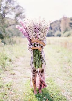 a woman is holding flowers in her arms