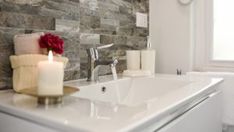 a white sink sitting next to a window in a bathroom